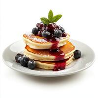 A stack of pancakes with blueberry sauce on top photo