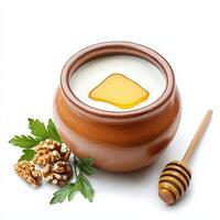 Yogurt with honey and walnuts in a clay pot on a white background photo