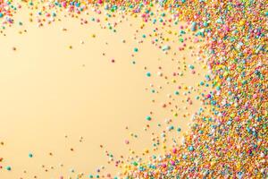 An assortment of colorful sugar sprinkles creates a vibrant border on a pastel background photo