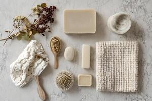 Assorted soap bars, brushes, and towels are neatly arranged on a marbled white surface photo