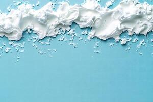 Fluffy, white cream borders a light blue backdrop, leaving space for textual addition here photo