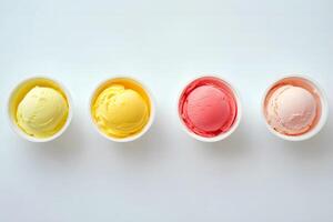 Four open tubs of colorful ice cream are sitting in a row on white photo
