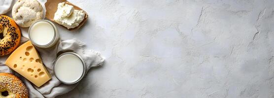Fromagerie still life shows bagels, cheese, two milk jars, and soft white bread photo