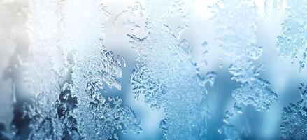 Intricate ice crystal patterns beautifully adorn a clear surface with a soft, wintery gradient photo