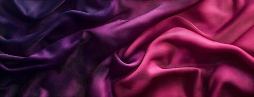 Purple and pink silk fabric drapes softly with a luxurious texture and vivid color photo
