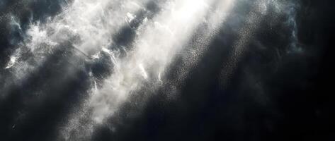 Radiant light illuminates swirling dust, creating ethereal wisps against a dark and moody background photo