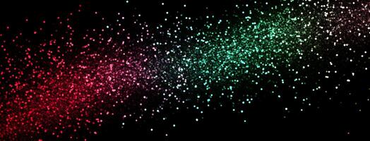 Red, pink and green particles create a sparkling colorful gradient effect against a black background photo