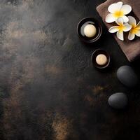 Spa stones, plumeria flowers, and soap in bowls are arranged on textured background photo