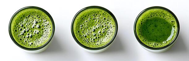 Three clear glasses showcase green, foamy matcha tea viewed from above on a white surface photo