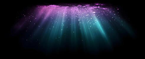 Turquoise rays descend from the violet surface through bright particles in a dark backdrop photo