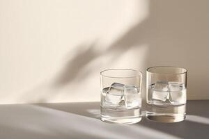 Two glasses of chilled water with ice cubes sit under gentle studio lighting photo