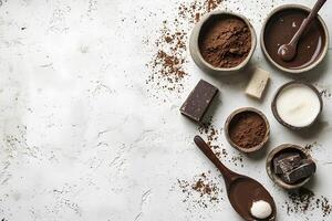 Various chocolate ingredients with cocoa powder, liquid chocolate, and bar pieces are arranged creatively on white textured background photo