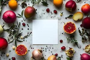 Various fruits, vegetables and foliage surround a blank white square card placed atop mottled surface photo