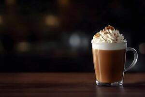 Warm beverage topped with whipped cream and walnut pieces sits on a brown table photo