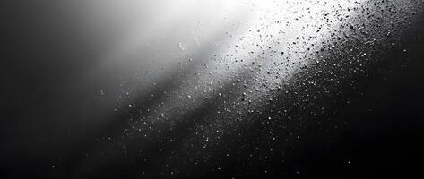White specks spread across a gradient of gray that darkens into a black background photo