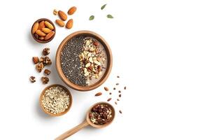 Wooden bowls display healthy smoothie, oats, assorted nuts, and seed mix viewed from overhead photo