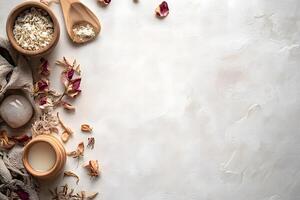Wooden bowls and spoons hold white flakes and powders, surrounding dried rose petals on marble photo