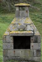 Fireplace made out of stone with a carved scallop shell on top along the Camino pilgrimage route photo