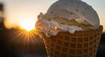 A waffle cone with ice cream and a sunset in the background photo