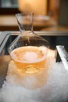 Decanter of rose champagne is cooled in a niche with ice in the restaurant, local lighting, wine cabinet, bubbles photo