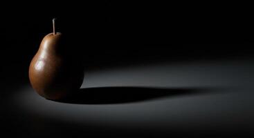 A pear is shown in the dark with a shadow photo