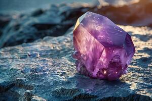 A purple stone sitting on top of a rock photo