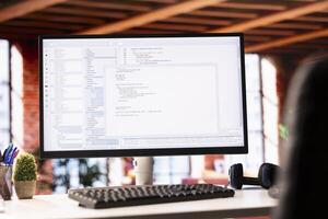 Programming code executing software UI on computer display in apartment office. Close up shot of coding application on PC screen used to write and test code in modern living room photo