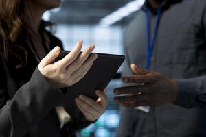 Teamworking data center admins using laptop, conducting security audits, preventing vulnerabilities. Close up of IT staff members using device to review firewall rules, logging incident details photo