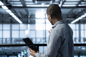 Technician in data center using tablet adjusting power management settings, verifying compliance requirements. Engineer in server room optimizes resource utilization, maintaining stable infrastructure photo