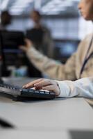 Technician in server room typing on keyboard, implementing power management solutions to reduce energy consumption. Close up of IT specialist integrating new technologies and systems in data center photo