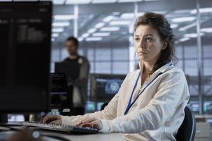 Data center programmer writing disaster recovery plans ensuring minimal downtime. Woman in server farm workplace uses analytics to monitor performance and predict future infrastructure needs photo