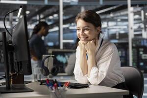 Jolly engineer in server hub satisfied by improved system efficiency metrics. Cheerful woman working in data center pleased by enhanced network infrastructure performance after finishing update photo