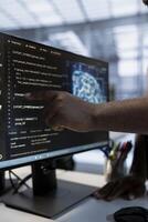 System administrator using machine learning applications to optimize server farm operations. IT expert pointing to PC monitor, implementing server virtualization in data center facility photo