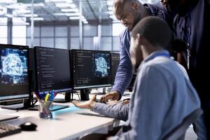 Teamworking coworkers doing brainstorming in server room, creating high performance AI systems on PC. Team of technicians in data center discussing with coworker, developing artificial intelligence photo