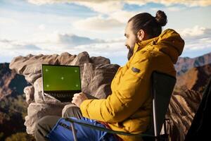 Pleased excited explorer enjoying the panoramic beauty with a green screen, admiring the rocky mountain range. Endless landscape symbolizing personal growth and mental clarity. Camera A. photo