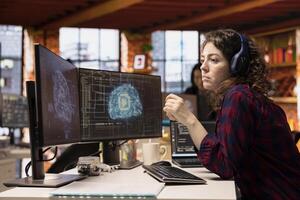 AI industry startup technician coding and listening podcasts in office to make time pass faster. Silicon Valley company worker wearing audio headset leveraging machine learning technology in workspace photo