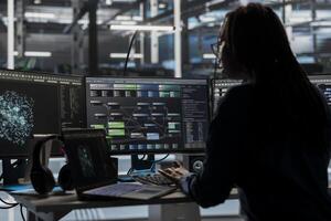 Data center software developer looks at AI visualization dashboard to pinpoint equipment performance issues. Server farm expert looks at node tree and data analysis graph on computer photo