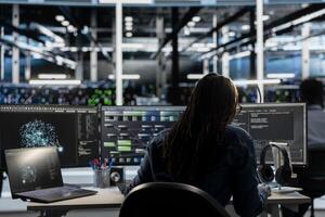 Data center programmer uses AI visual programming technology to oversee automated repetitive tasks. Server room employee modifying infrastructure rigs systems based on data analytics graphs photo