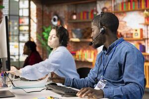 Call center agent talking in headset mic, helping customers regain access to accounts and devices. Customer center employee assisting clients needing help resetting password photo