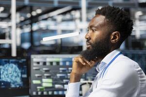 Data center workplace technician using artificial intelligence neural networks technology. Server hub specialist using AI programming language on computer, configuring specialized hardware photo