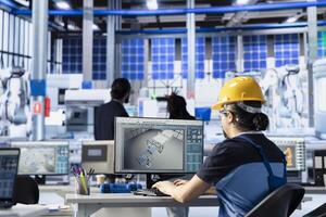 Green energy photovoltaics factory engineer adjusting system parameters on PC to maximize power generation. Technician optimizing energy supply in eco friendly solar panel manufacturing plant photo