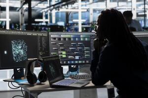 Data center engineer implements AI driven virtualization frameworks to optimize server clusters. Server hub employee does artificial intelligence predictive analysis using visual programming photo