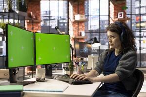 Digital media professional works with isolated copy space at an agency, using smart workstation with dual monitors. Efficient workspace supports multitasking and artificial intelligence development. photo