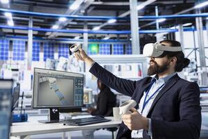 Photovoltaics factory technician using VR goggles to do performance testing of solar panel designs. Employee improving existing solar panel configurations for cost reduction using virtual reality photo