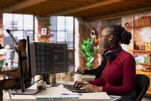 Startup employee using large language model application to get help with coding tasks. Woman interacting with AI LLM chatbot PC GPT software on PC in software development workplace photo