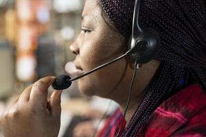 Call center agent using headset mic to answer customers technical inquiries, assisting with questions about hardware issues. Woman in doing customer service, troubleshooting problems, close up photo