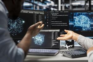 Server farm engineering team looks at data analysis graph to reduce supercomputers failure. Data center coworkers look at AI visualization dashboard to pinpoint gear performance glitches photo