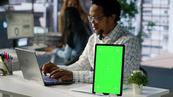 Professional executive analyzing monthly reports next to chroma key display, working on strategy planning and financial forecasts. Business developer looking into data for decision making. Camera A. photo