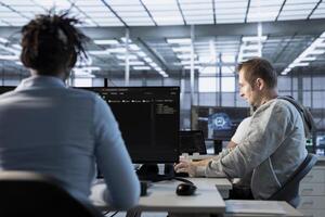 AI technician at work in high tech server room analyzing data on monitors, ensuring seamless data flow. Man in artificial intelligence data center, ensuring system integrity and security photo