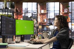 Freelancer woman utilizing AI powered software next to green screen to improve productivity at the office. Virtual assistant showcases how automation and machine learning transform daily tasks. photo
